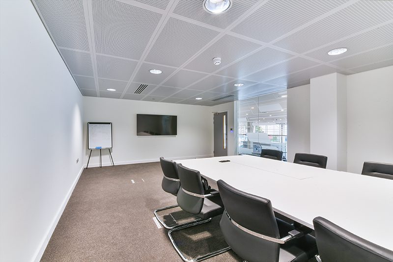 new office fitted out with new office furniture. long table with grey chairs.