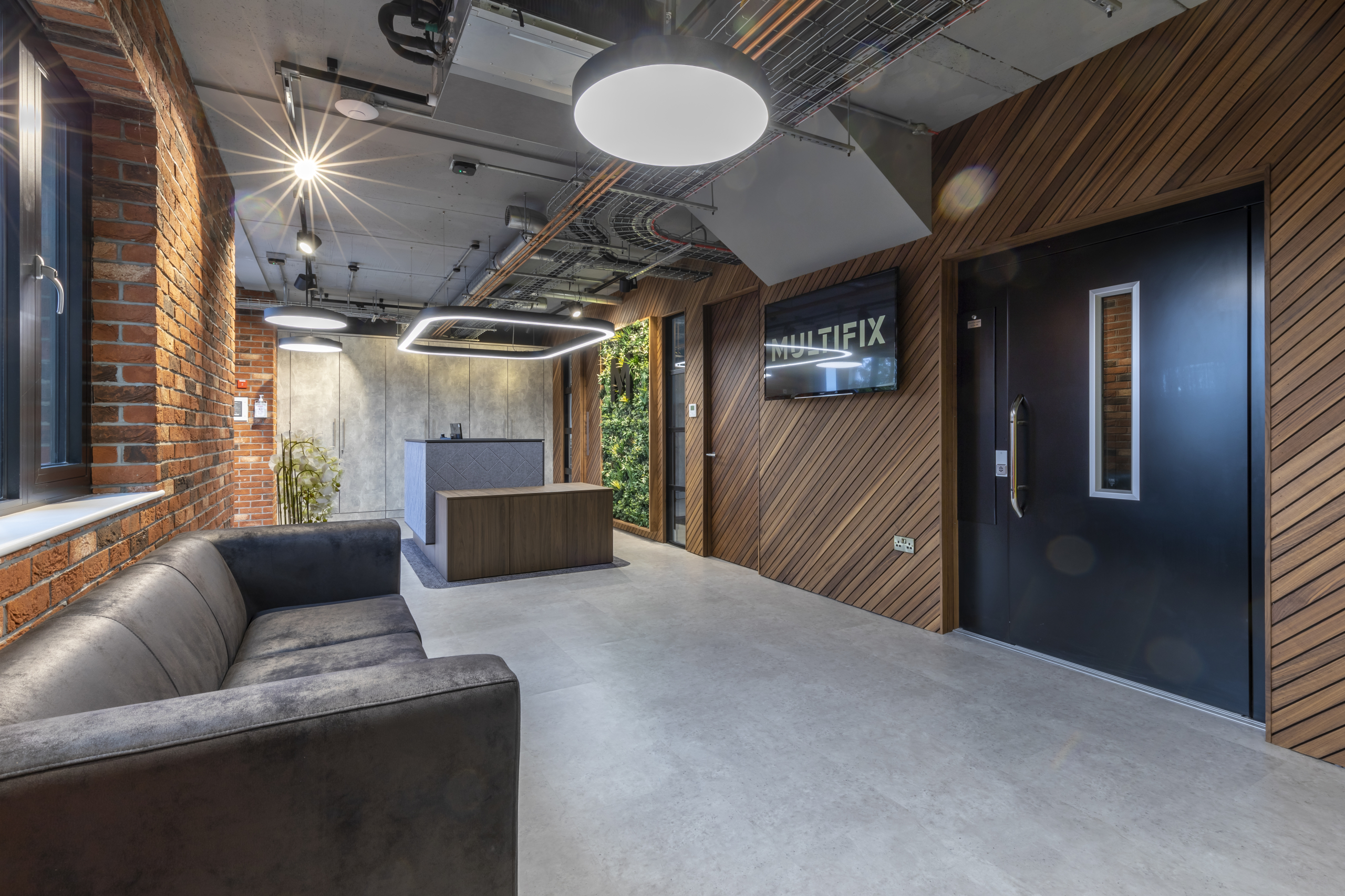 new reception area with new grey sofa in office with acoustic wooden partitions