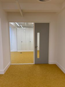 Glass partition next to a paint grade door in an office space