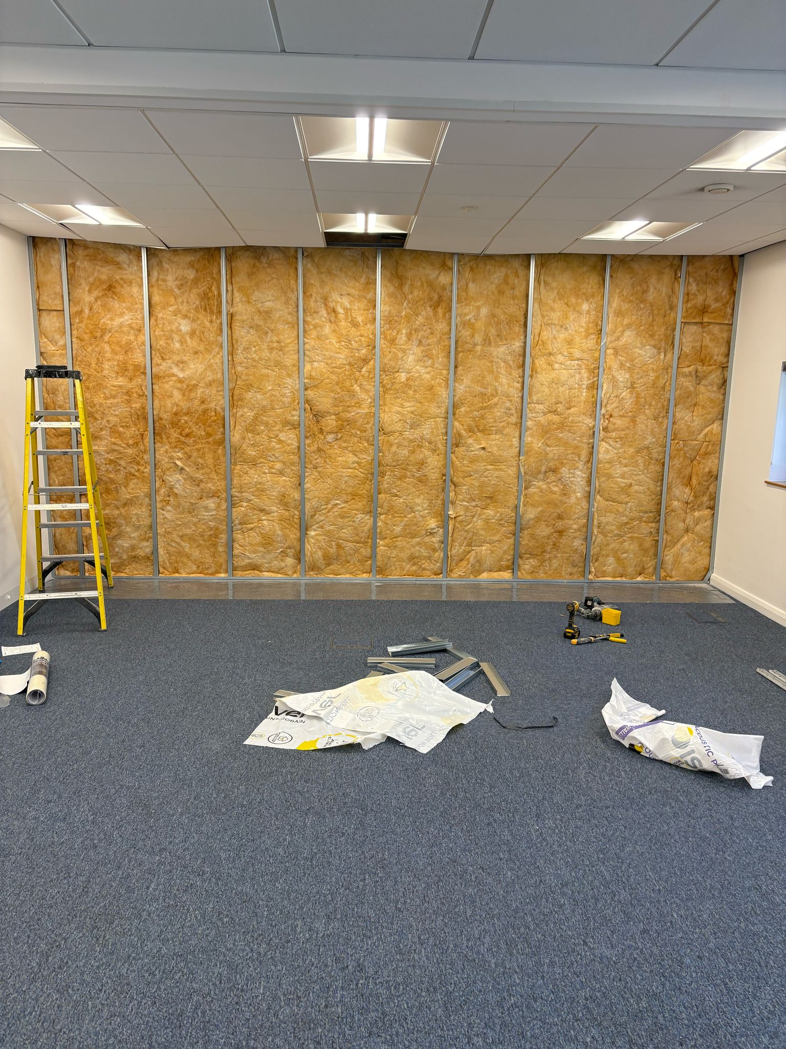 insulated wall A drywall partition filled with acoustic insulation in a new office.